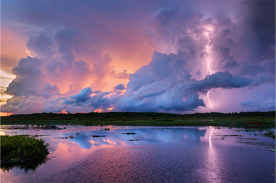 Lightning striking over lake