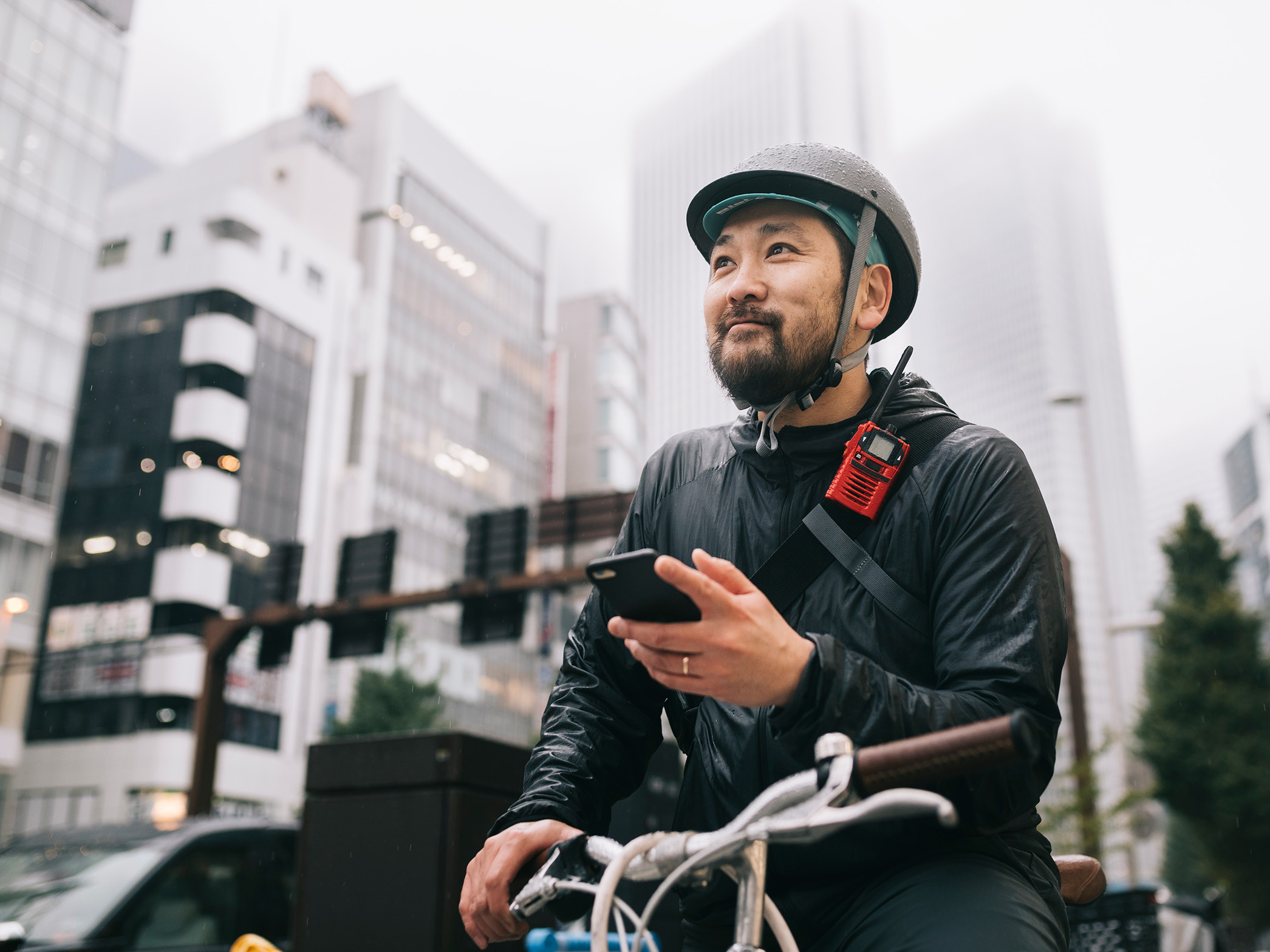 Person sitting on a bicycle holding phone