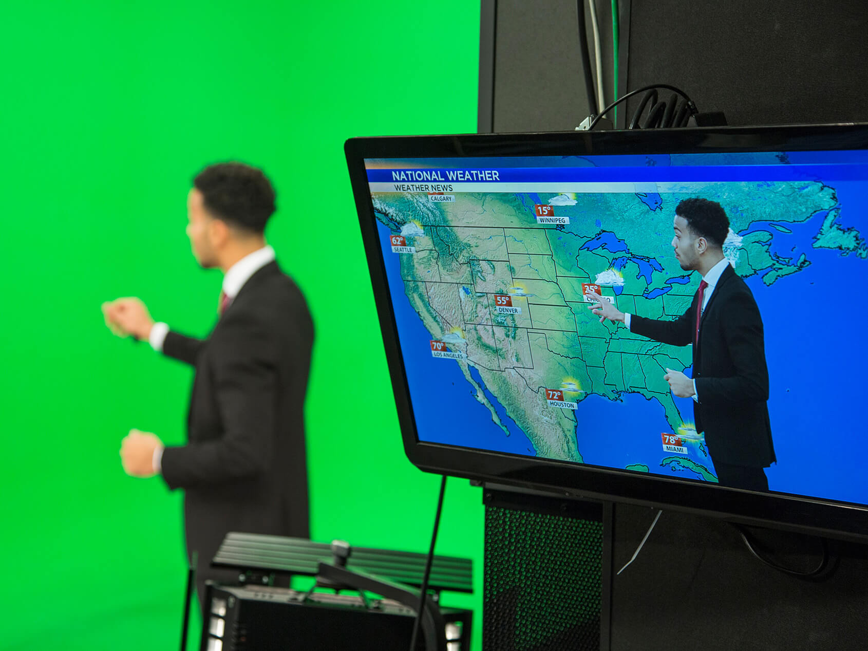 Meteorologist in front of green screen with monitor