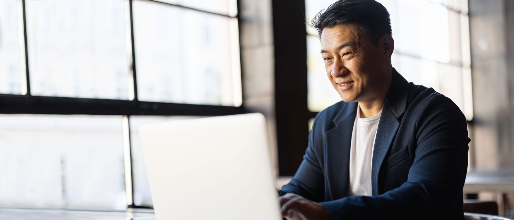 hero-asian-man-suit-on-laptop-manager-shutterstock_2074091120