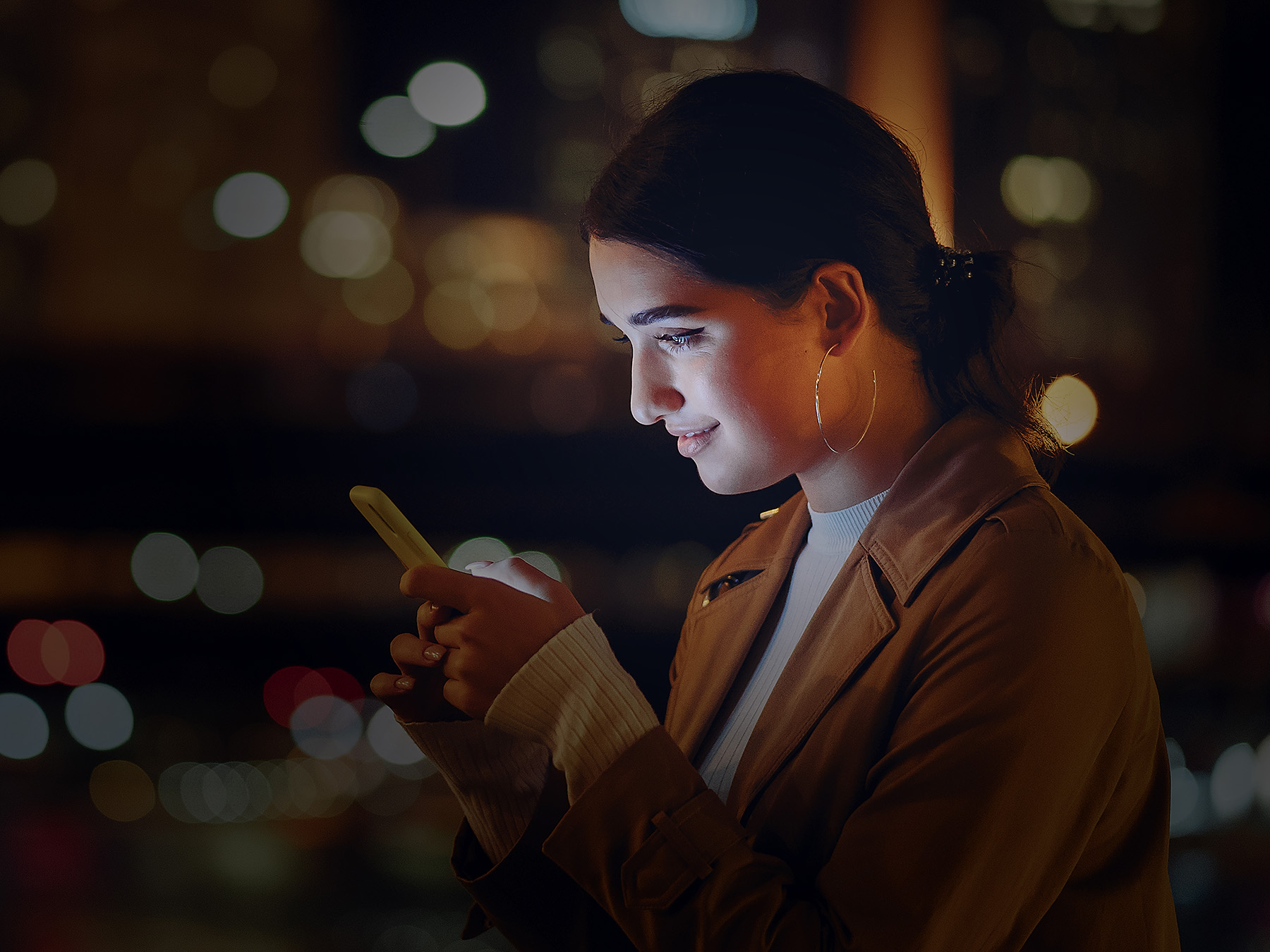 Woman engaged with her phone at night