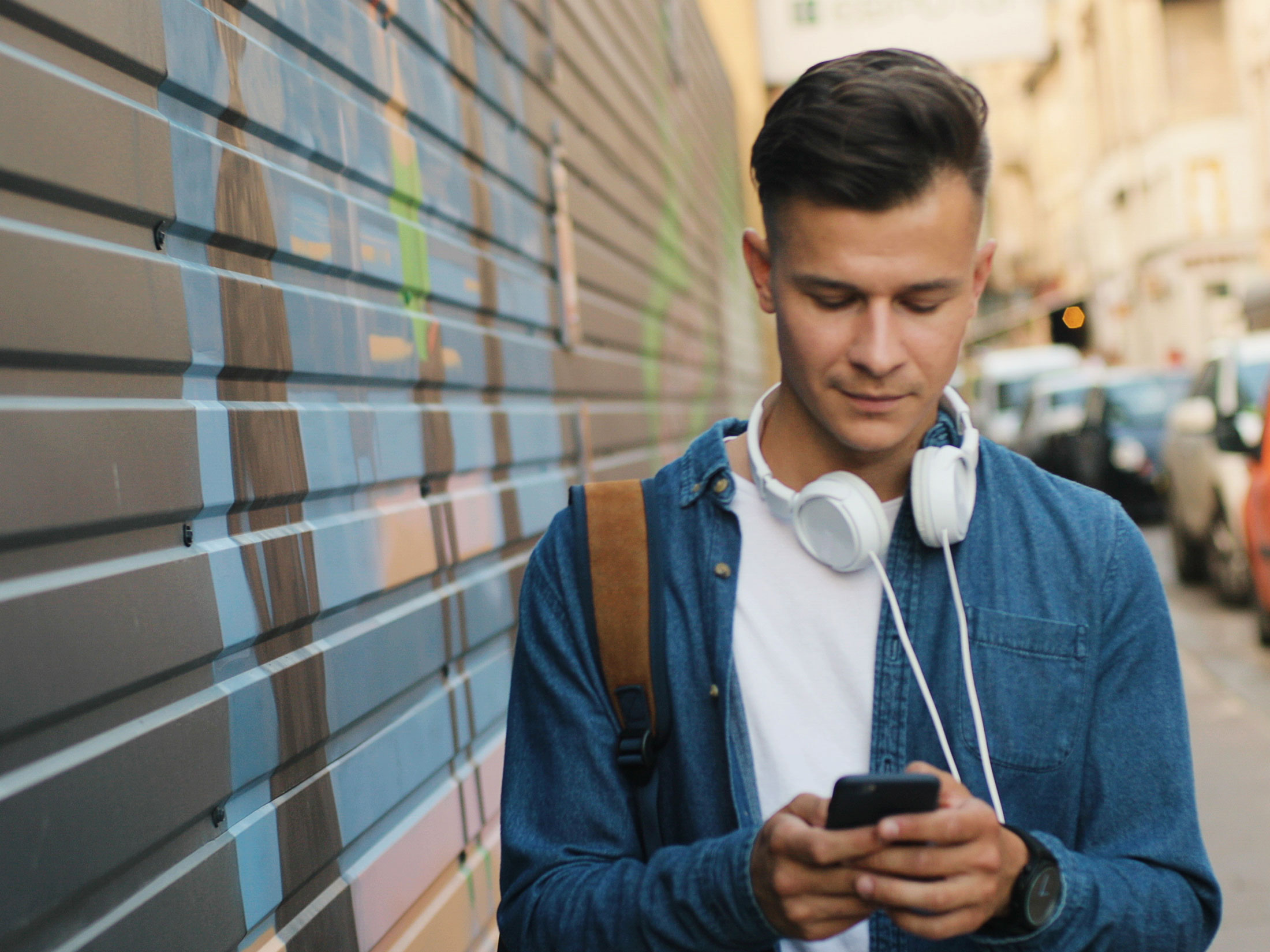 Man walking down the street looking at his phone