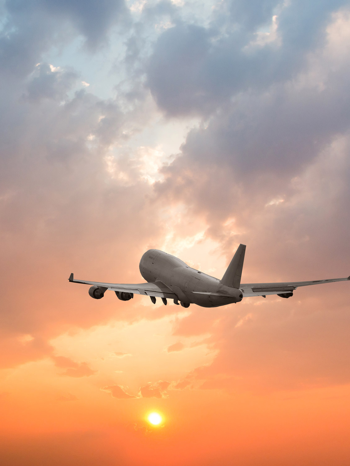vertical-tab-aviation-airplane-flying-clouds-sunset-shutterstock_1104066083