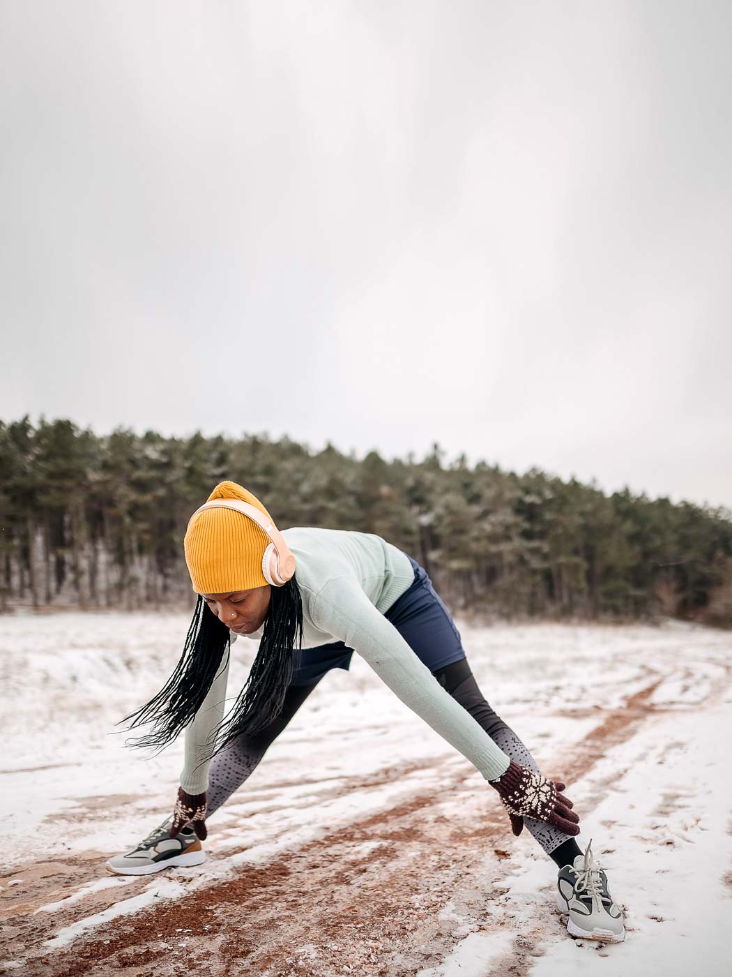 vertical-woman-stretch-snow-GettyImages_1359167778