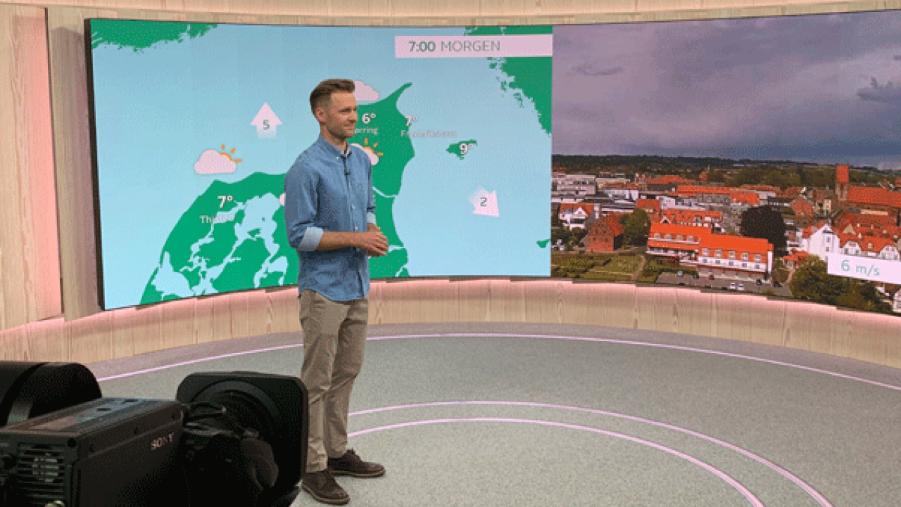 On-air weather talent standing in front of a weather map in a studio