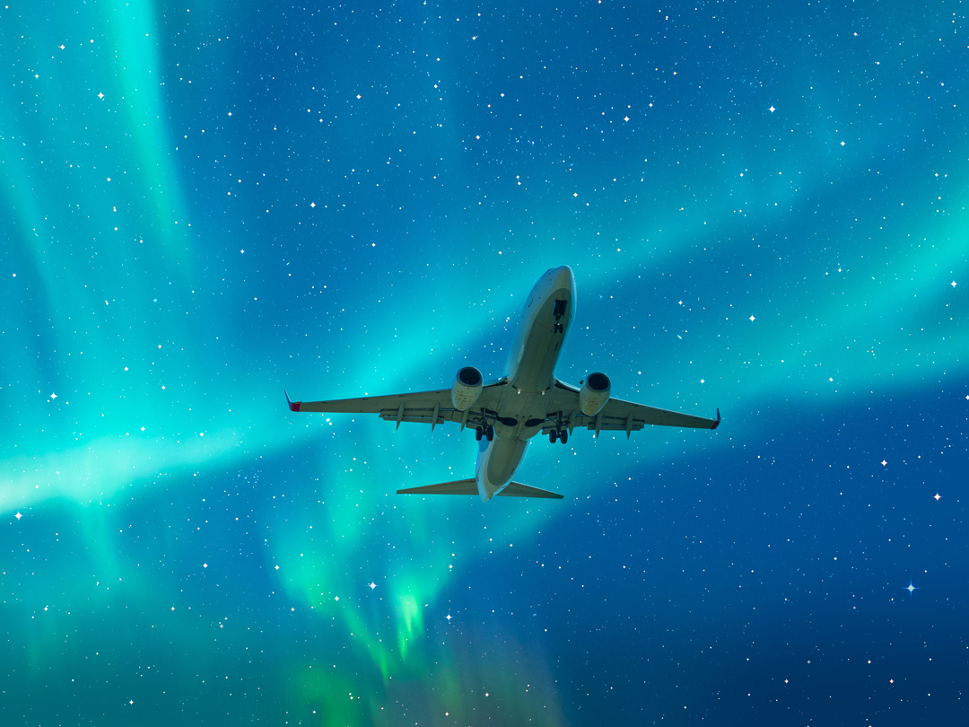 Airplane in sky with northern lights