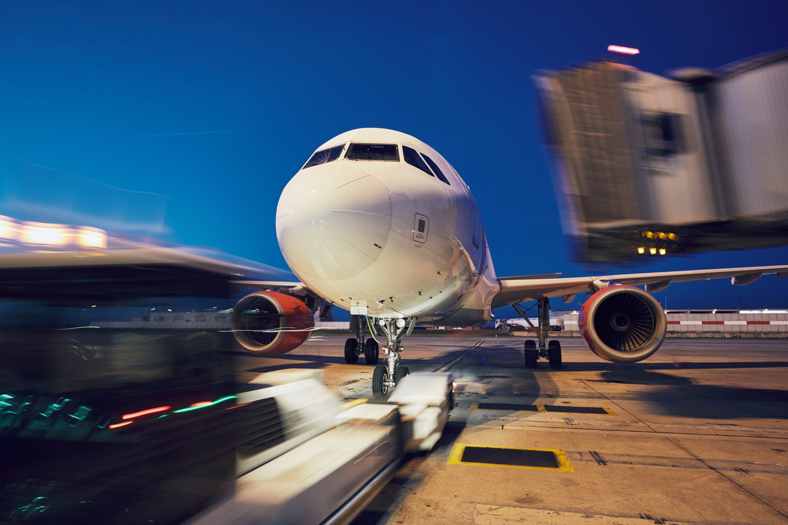 Busy airport at night. Push back of the airplane before flight.