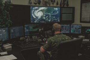 A hurricane warning broadcast in a command center, with meteorologists tracking the storm path on large screens
