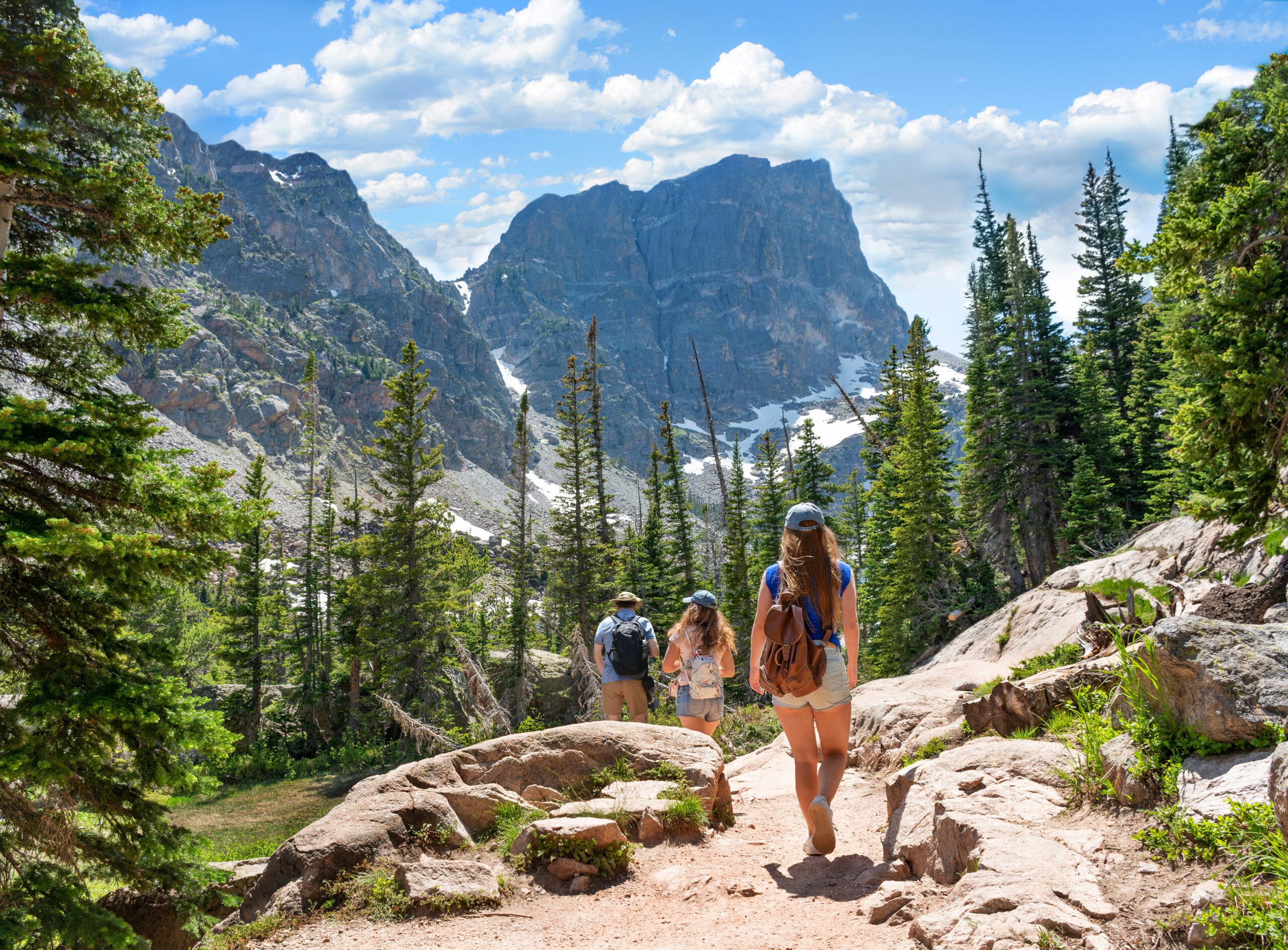 Family on summer vacation hiking trip in the mountains.