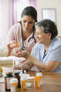Hispanic nurse helping senior woman with medication