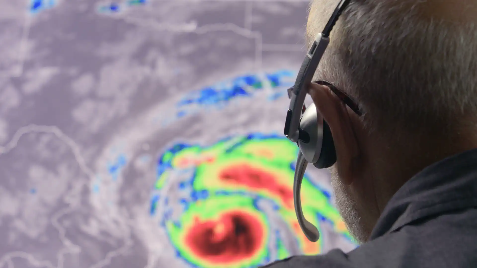 A meteorologist looking at a live hurricane radar.