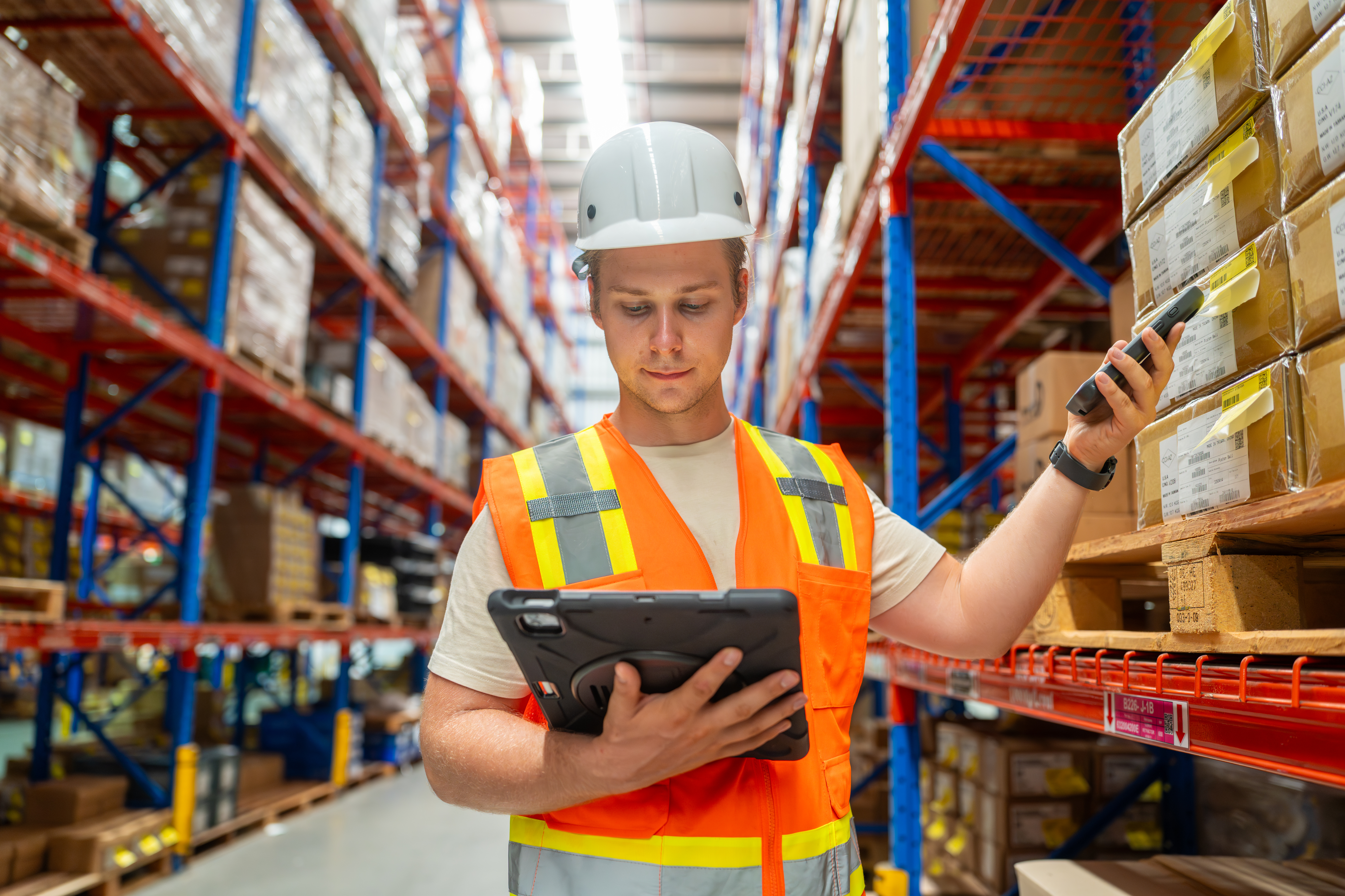 A worker taking an inventory of retail goods in a warehouse.