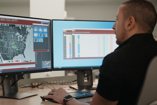 Meteorologist looking at weather data on a computer screen at his desk
