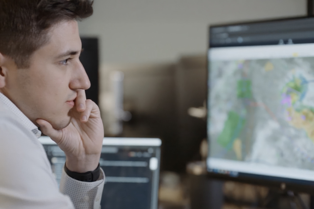 Meteorologist sitting at a desk with laptop verifying weather forecasting data for an airline.