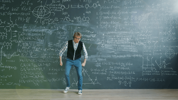Man dancing in front of a giant chalkboard