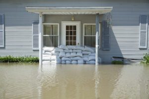Facade of flooded house with wall made of bags with sand