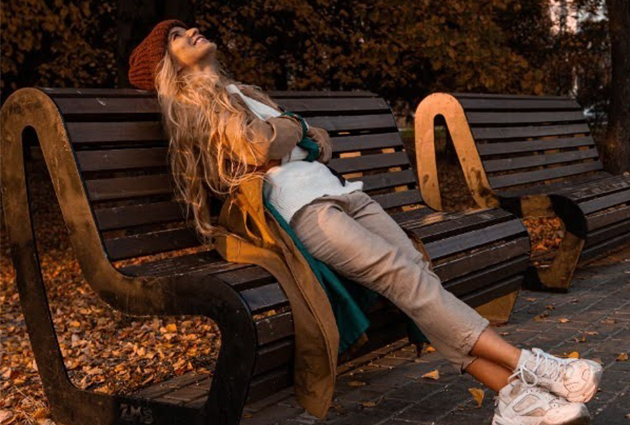 Woman on a bench taking in the fall weather